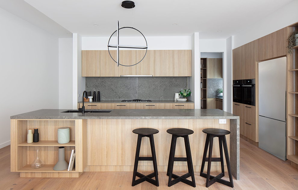 Modern kitchen with timber cabinetry and grey stone island bench top