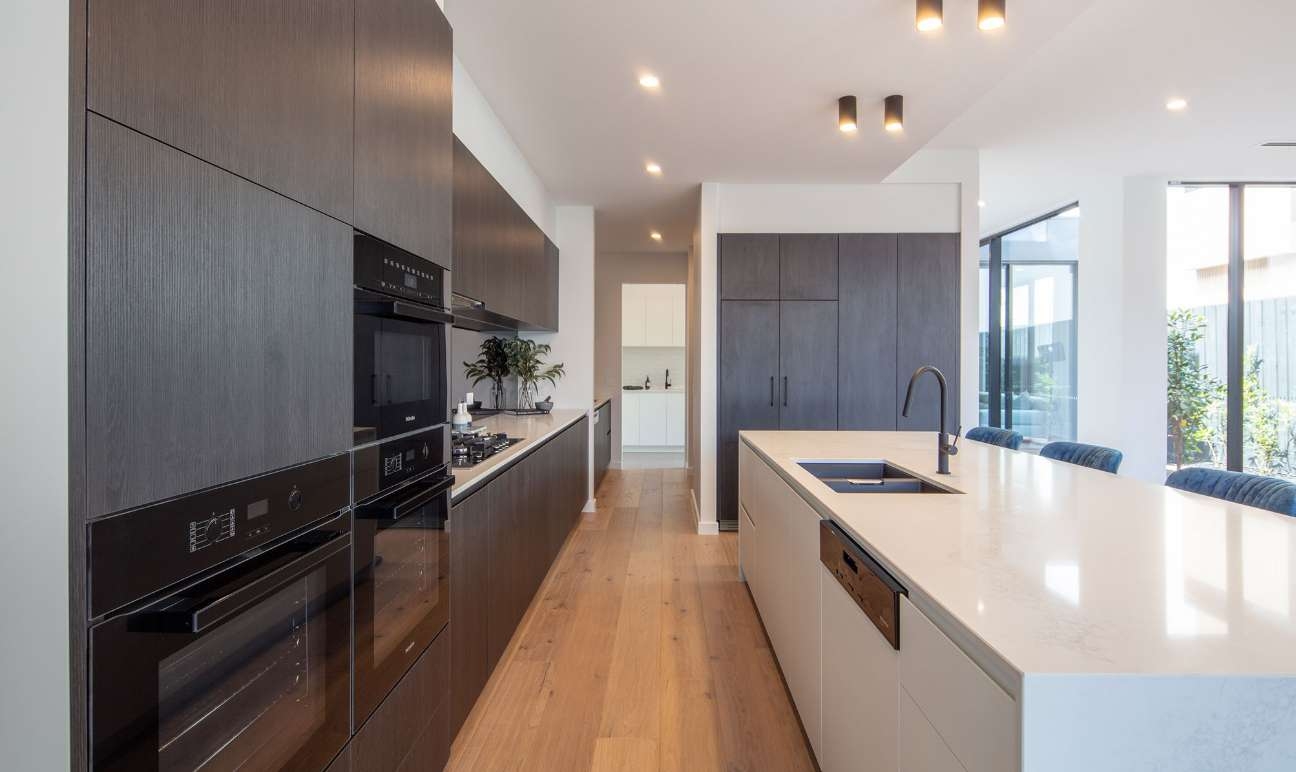 Modern kitchen with black cabinetry and white stone island