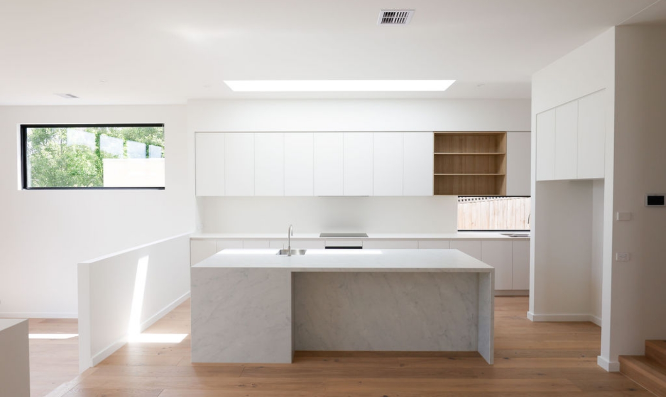 Modern kitchen with white cabinetry and stone island