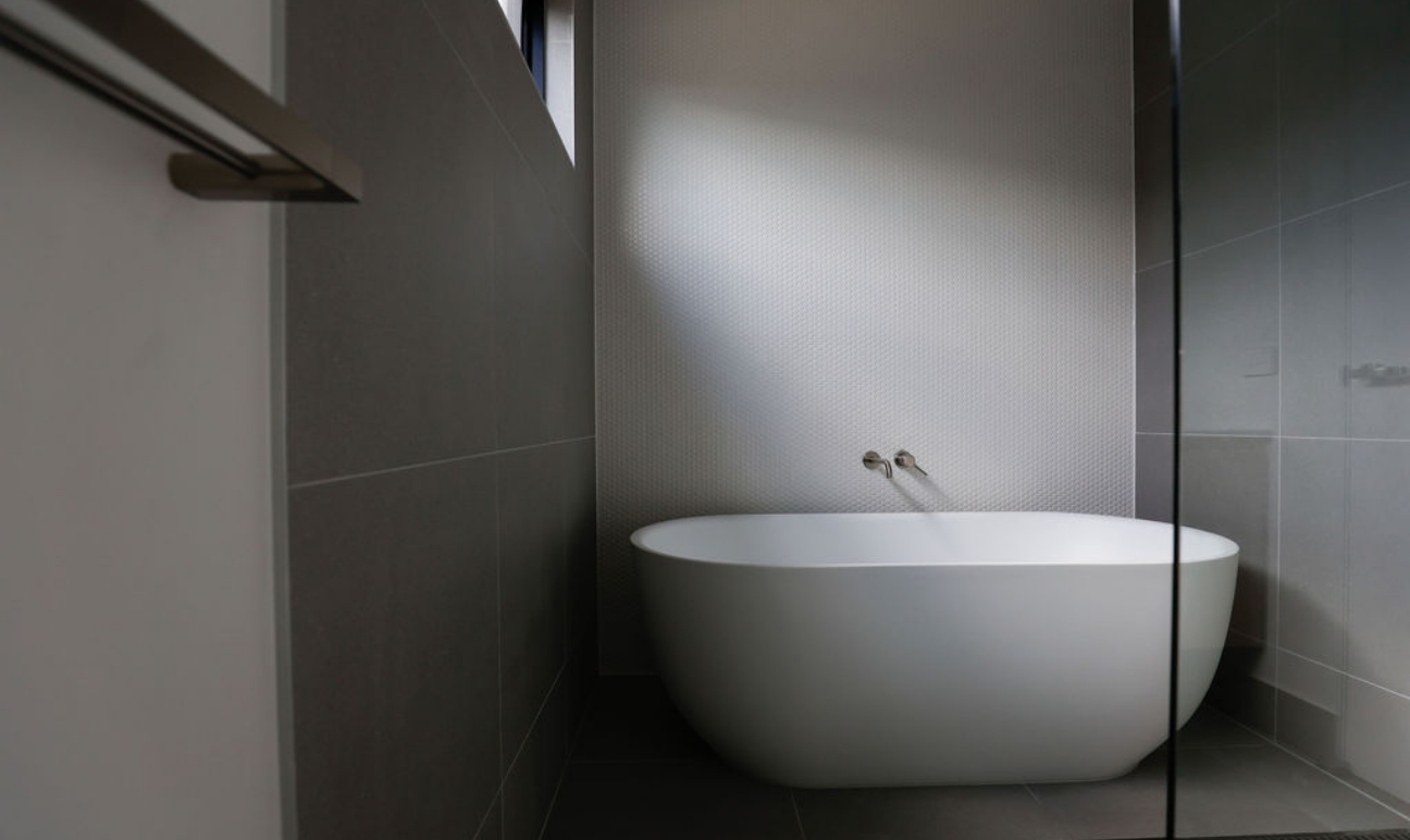 Bathroom with large white bathtub and grey walls