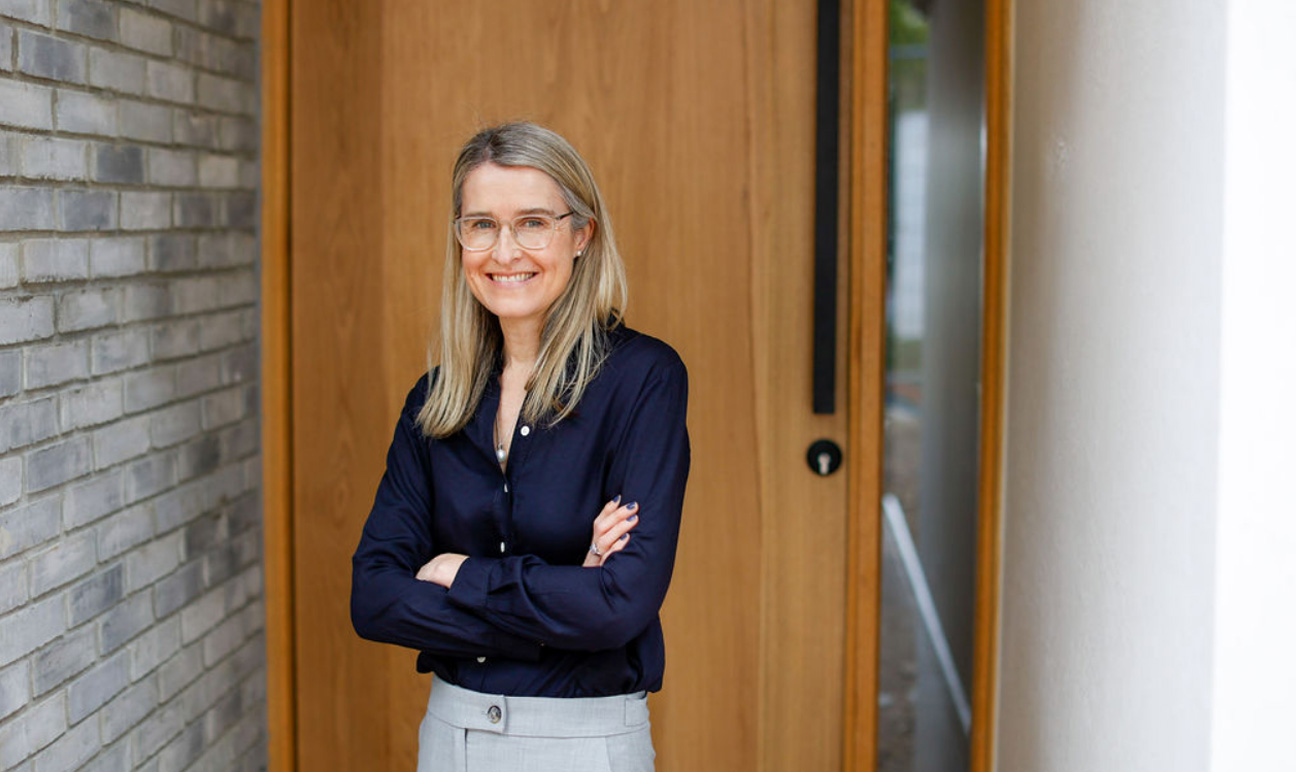 Smiling woman standing in front of timber front door