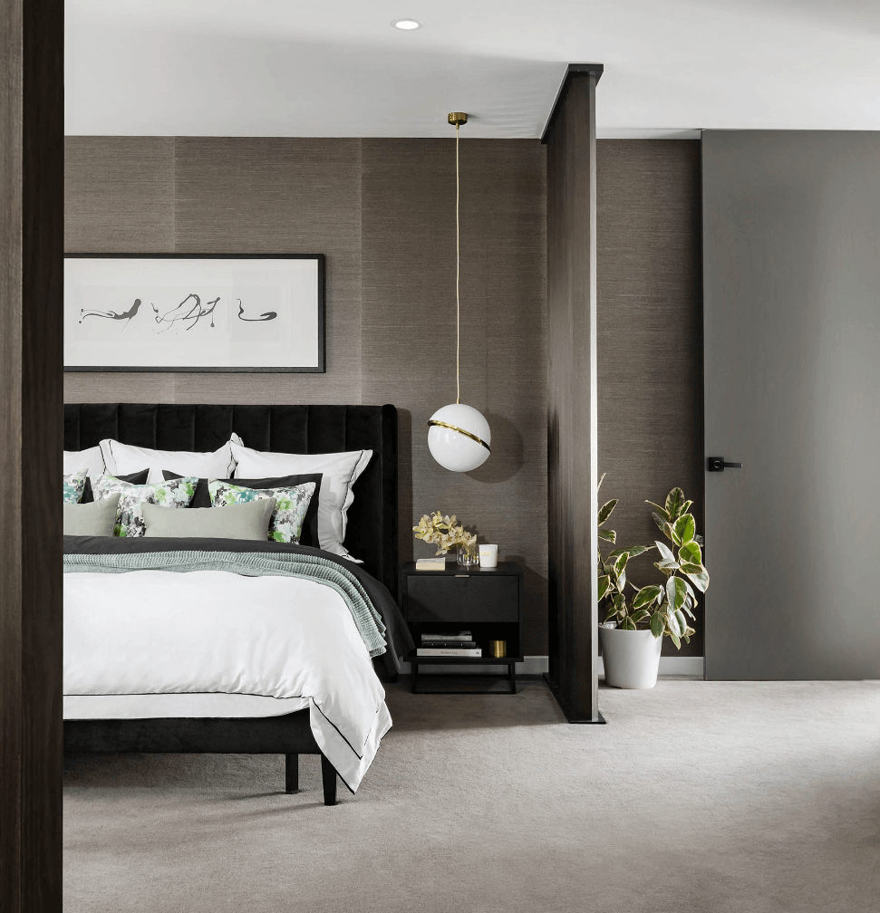 Bedroom with grey-brown walls, large bed, bedside table and indoor plant