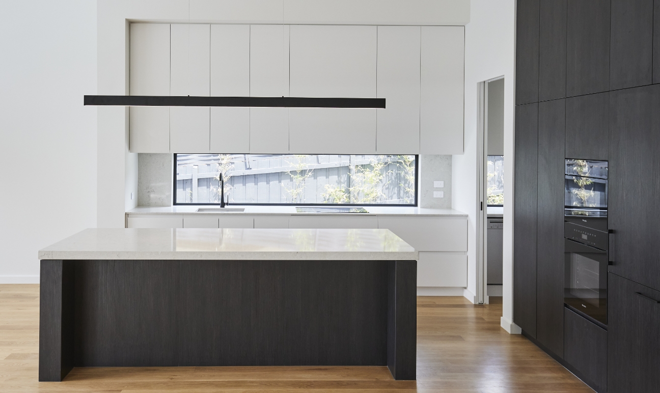 High-end kitchen with black and white cabinetry and timber flooring