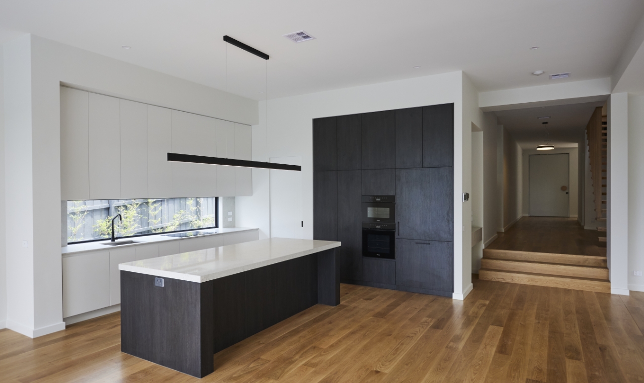 High-end kitchen with black and white cabinetry and timber flooring