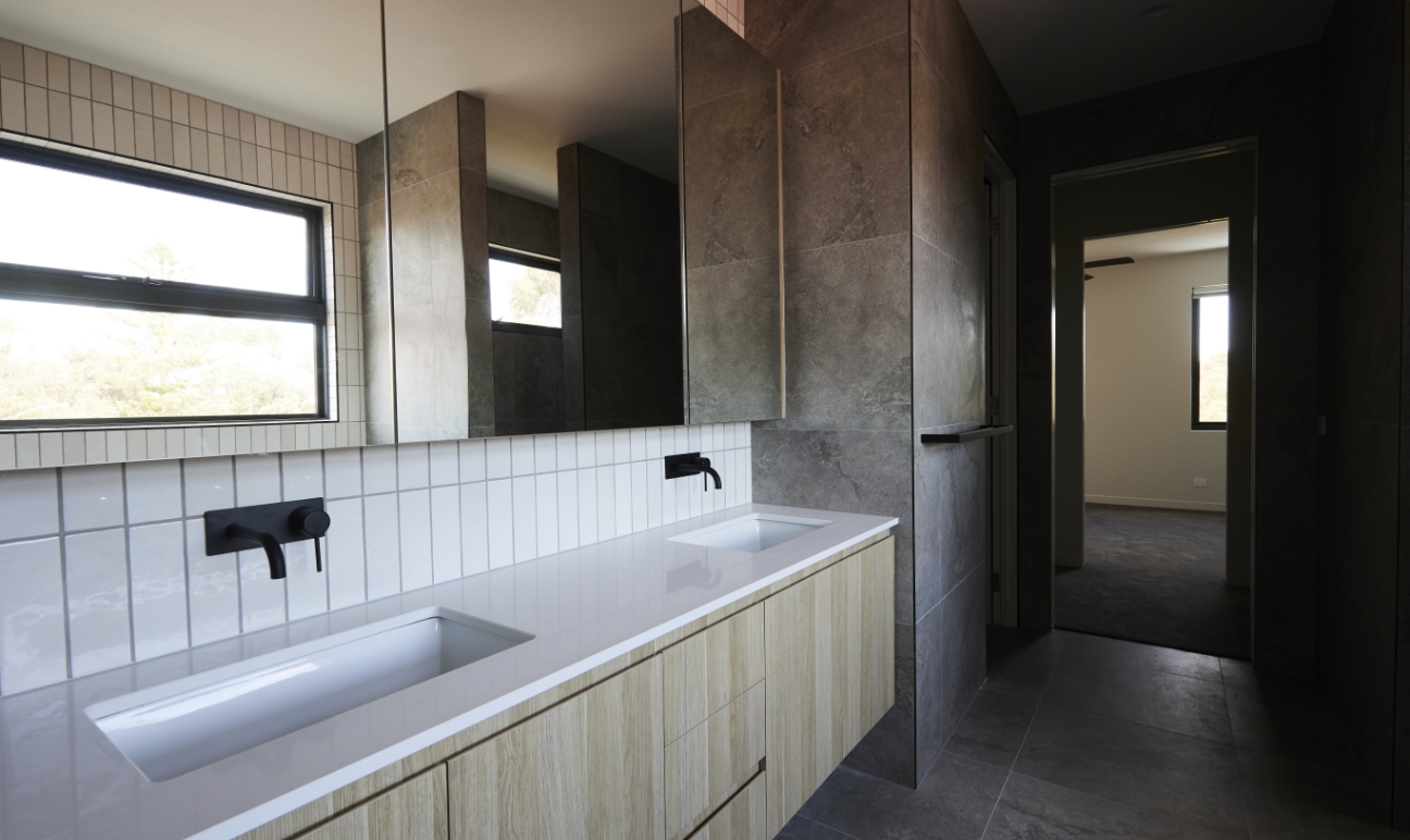 Bathroom with double vanity, timber cabinetry and mirrored cupboards