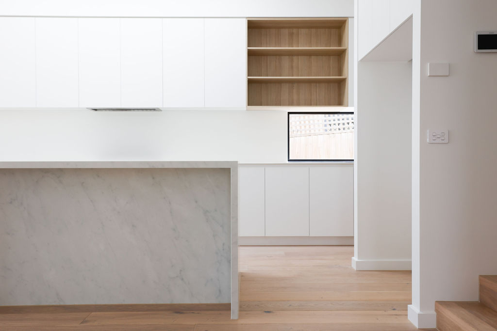 Kitchen with white cabinetry and stone island