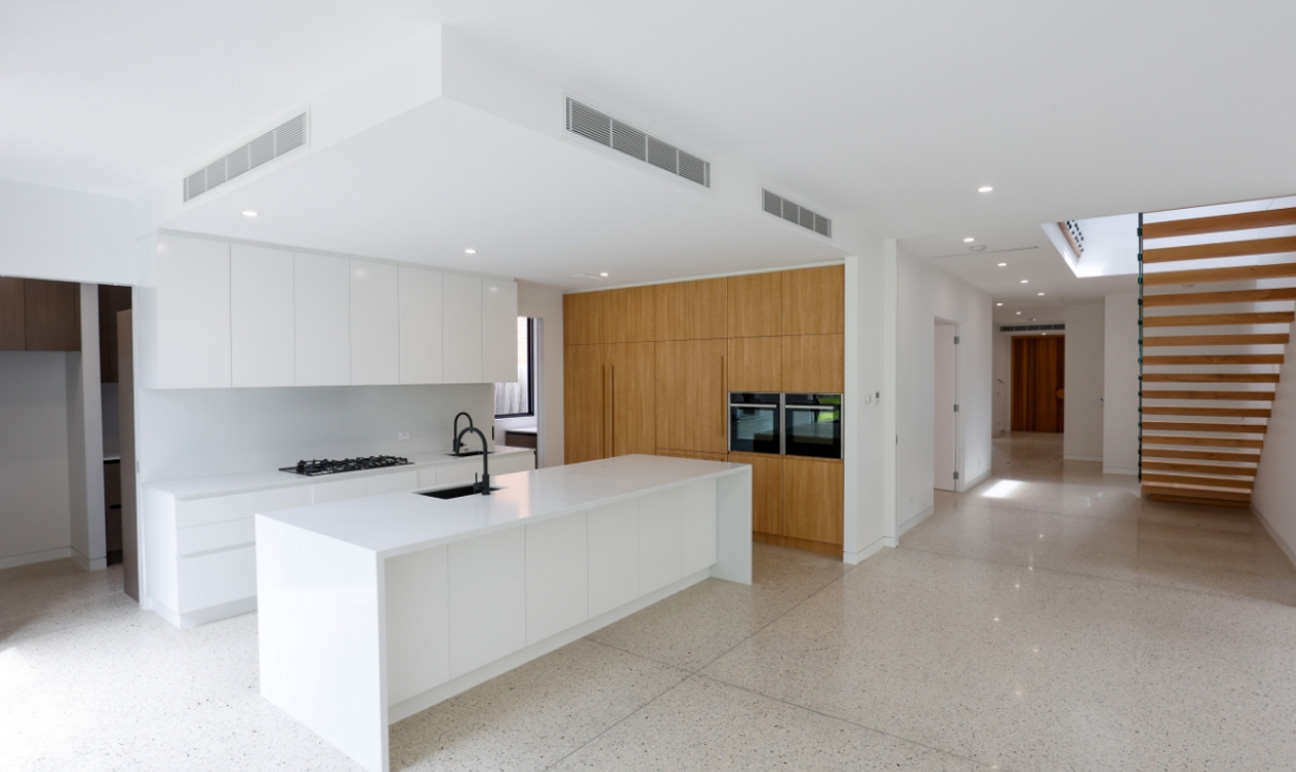 Modern kitchen with white & timber finish cabinetry and white stone island