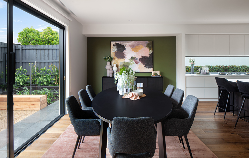 Dining area with table and chairs next to glass sliding doors to the outdoor area