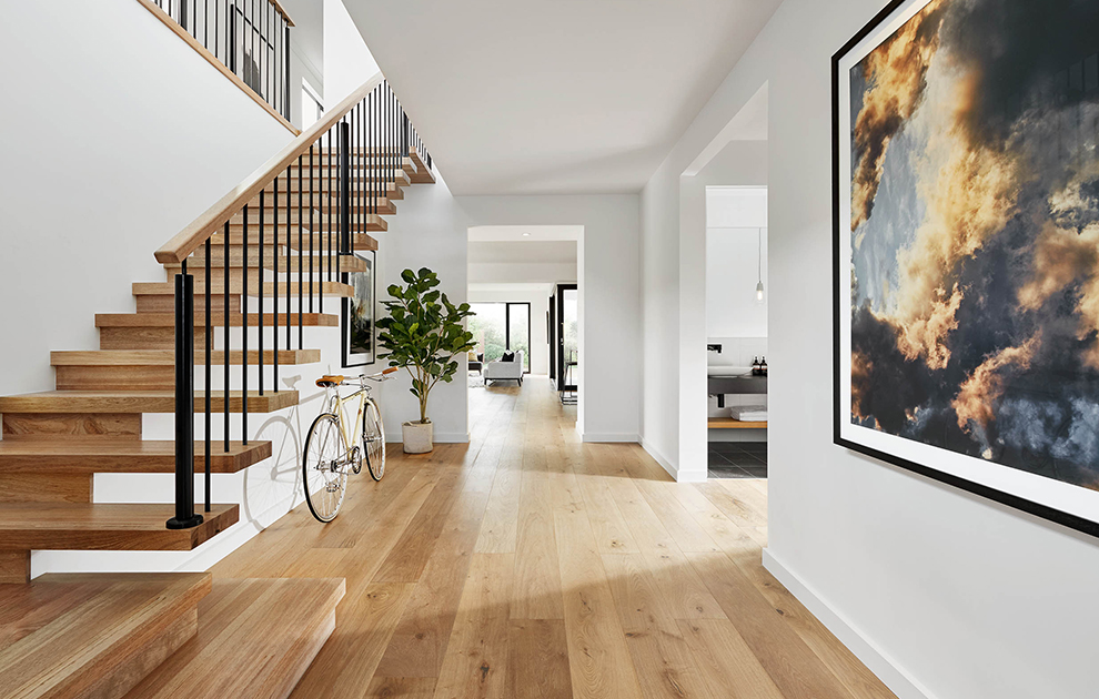 Bright hallway with timber floor and staircase leading to second storey