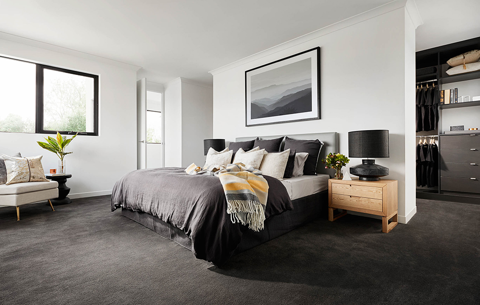 Master bedroom with dark furnishings leading into walk-in wardrobe with custom cabinetry