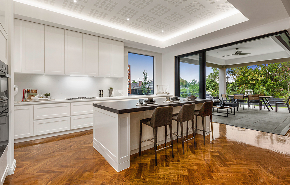 Modern kitchen with white cabinetry and herringbone timber flooring