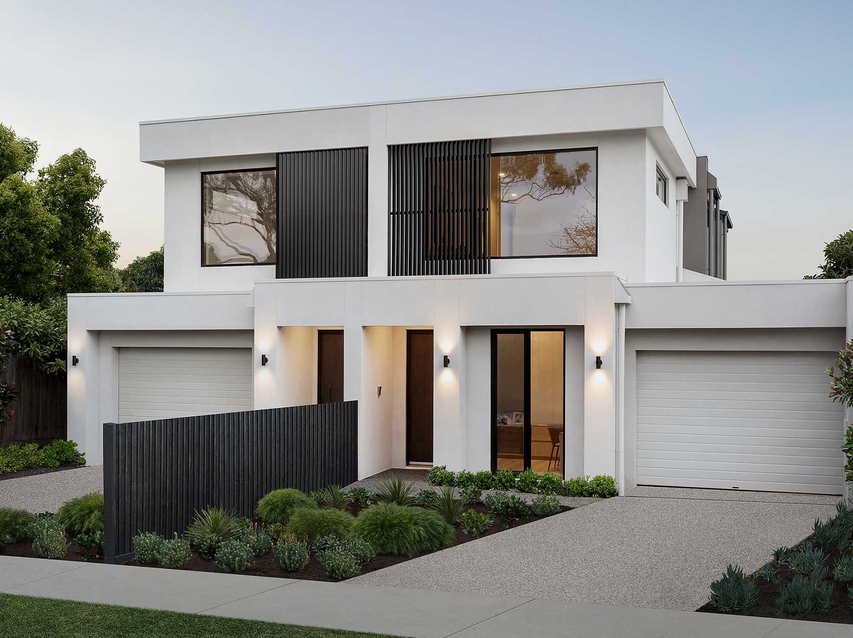 Contemporary white two-story home with large windows, black vertical louvers, and a landscaped front yard.