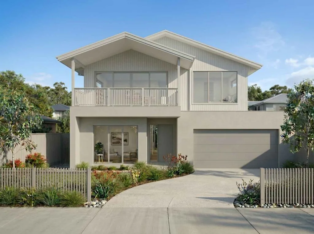 Modern two-story beige home with a balcony, large front window, and a two-car garage, set behind a low fence and landscaping.