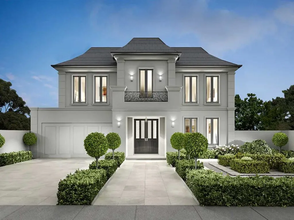 Two-story gray contemporary house with a central entry, double front doors, and a small balcony above, flanked by large windows and manicured shrubs.