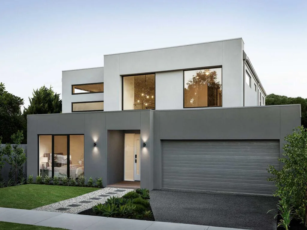Modern gray two-story house with large front windows, a wide garage door, and neatly landscaped yard.